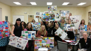 A group of people holding up their vision boards after a successful vision coaching session with Terri L. Moore.